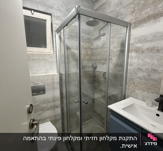 חדר אמבטיה עם מקלחון זכוכית, כיור ואסלה